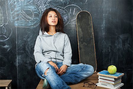 young cute teenage girl in classroom at blackboard seating on table smiling close up Stock Photo - Budget Royalty-Free & Subscription, Code: 400-08413432