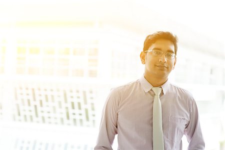 Portrait of 30s Asian Indian businessman standing outside office. India male business man, modern office building with golden sunlight at background. Stock Photo - Budget Royalty-Free & Subscription, Code: 400-08427546