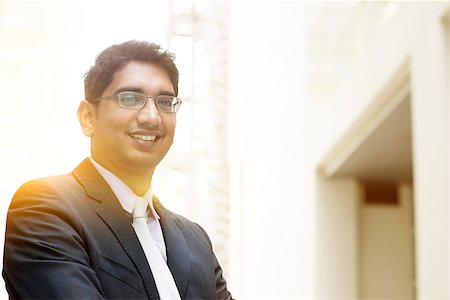 Portrait of Asian Indian business man smiling, outside modern office building block, beautiful golden sunlight at background. Stock Photo - Budget Royalty-Free & Subscription, Code: 400-08427559