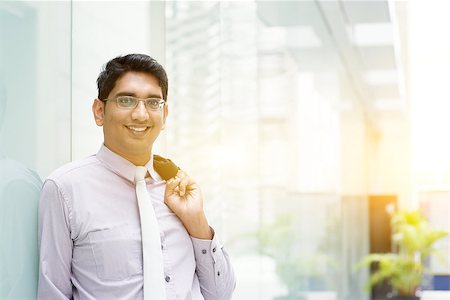 Portrait of Asian Indian business man smiling, leaning on modern office building block, beautiful golden sunlight at background. Stock Photo - Budget Royalty-Free & Subscription, Code: 400-08427560