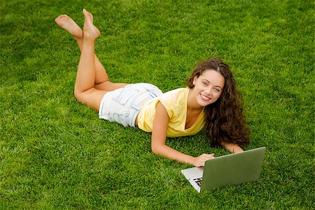 Beautiful young woman lying on the grass and working with a laptop Stock Photo - Budget Royalty-Free & Subscription, Code: 400-08427962