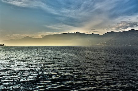 sunset over the lake major with the mists of the horizon and mountains in the background on a winter afternoon, Luino - Lombardy, Italy Stock Photo - Budget Royalty-Free & Subscription, Code: 400-08428571