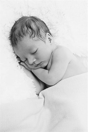 simsearch:400-07211187,k - Adorable sleeping newborn baby boy with hands under head. Copy space. Vertical composition. Photographie de stock - Aubaine LD & Abonnement, Code: 400-08428603