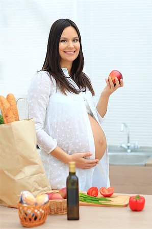 pregnant cooking - Pregnant woman eating the apple on the background of a package with products Stock Photo - Budget Royalty-Free & Subscription, Code: 400-08428791