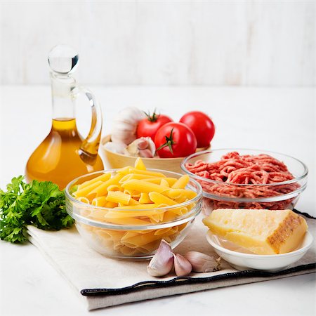 Italian food ingredients: pasta, tomatoes, herbs, minced and spices on wooden background Photographie de stock - Aubaine LD & Abonnement, Code: 400-08428894