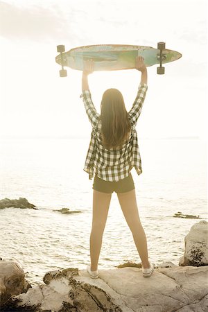 Beautiful and fashion young woman posing at the sunset with a skateboard Stock Photo - Budget Royalty-Free & Subscription, Code: 400-08429597