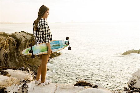 Beautiful and fashion young woman posing at the sunset with a skateboard Stock Photo - Budget Royalty-Free & Subscription, Code: 400-08429599