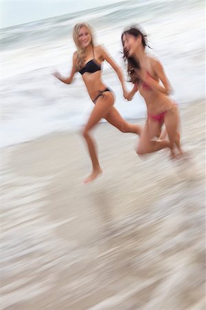 simsearch:400-08291180,k - Motion blurred photograph of young women girls in bikinis running on a beach Foto de stock - Royalty-Free Super Valor e Assinatura, Número: 400-08430025