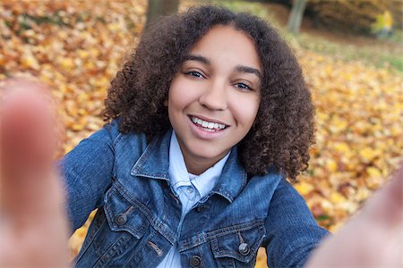 simsearch:400-04068097,k - Beautiful happy mixed race African American girl teenager female child smiling with perfect teeth taking selfie photograph Stockbilder - Microstock & Abonnement, Bildnummer: 400-08430069