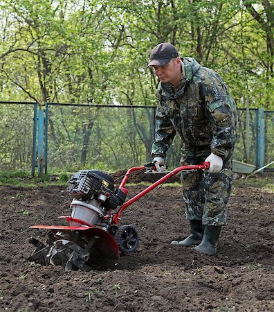 A man working in the garden preparing ground cultivator at the beginning of the spring season Stock Photo - Budget Royalty-Free & Subscription, Code: 400-08430756