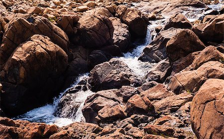 Stream of water flowing and splashing among bare red rocks,  at Tablelands, Gros Morne National Park, Newfoundland, Canada. Fotografie stock - Microstock e Abbonamento, Codice: 400-08430976