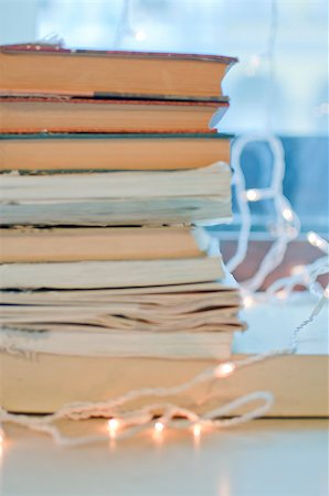 Stack of books and Christmas garland on the background of the window Stockbilder - Microstock & Abonnement, Bildnummer: 400-08431333