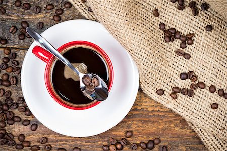simsearch:400-04476908,k - Coffee beans on spoon on top of coffee cup with surrounding coffeebeans gunny textile Stock Photo - Budget Royalty-Free & Subscription, Code: 400-08431509