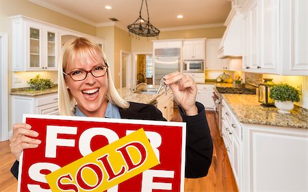 Happy Young Woman Holding Sold For Sale Real Estate Sign and Keys Inside Beautiful Custom Kitchen. Stock Photo - Budget Royalty-Free & Subscription, Code: 400-08431546