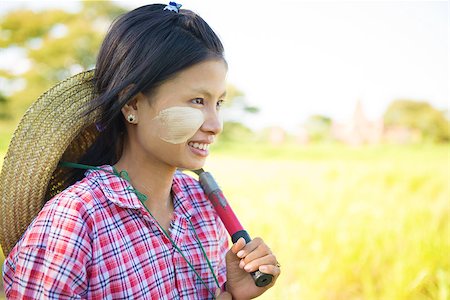 simsearch:400-06751673,k - Portrait of a young Burmese girl farmer with thanaka powdered face working in field. Fotografie stock - Microstock e Abbonamento, Codice: 400-08431827