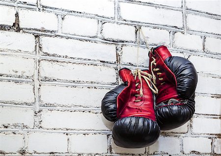 A pair of old boxing gloves hanging on white brick wall background. Stock Photo - Budget Royalty-Free & Subscription, Code: 400-08432234