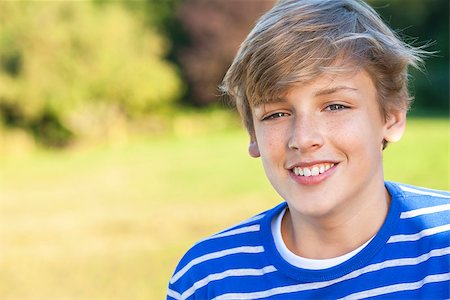 Young happy smiling male boy teenager blond child outside in summer sunshine wearing a blue sweatshirt Stock Photo - Budget Royalty-Free & Subscription, Code: 400-08432860