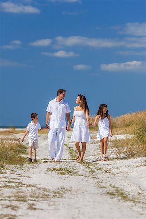simsearch:400-04235471,k - A happy family of mother, father and two children, son and daughter, walking holding hands and having fun in the sand of a deserted sunny beach Stock Photo - Budget Royalty-Free & Subscription, Code: 400-08432872