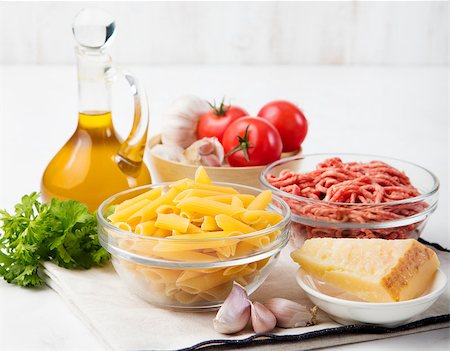 Italian food ingredients: pasta, tomatoes, herbs, minced and spices on wooden background Photographie de stock - Aubaine LD & Abonnement, Code: 400-08432895