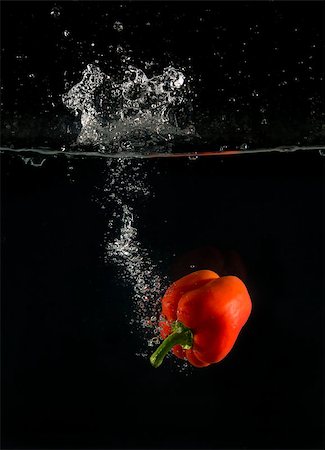 View of sweet pepper droping into water on black background. Foto de stock - Royalty-Free Super Valor e Assinatura, Número: 400-08432951