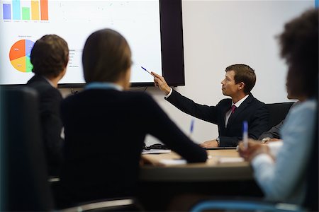 simsearch:400-05009097,k - Group of business people meeting in corporate conference room, smiling during a presentation. The coworkers are examining charts and slides on a big TV monitor Stock Photo - Budget Royalty-Free & Subscription, Code: 400-08433253