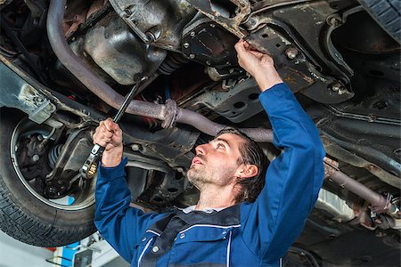 Portrait of a young male mechanic checking the condition of a lifted car Stock Photo - Budget Royalty-Free & Subscription, Code: 400-08433270