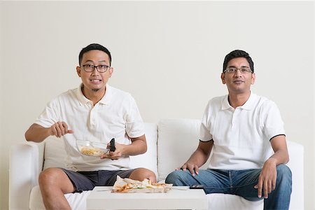 Group of friends sitting on sofa watching TV together at home. Stock Photo - Budget Royalty-Free & Subscription, Code: 400-08494554