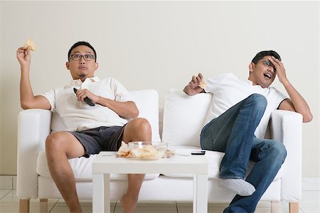 Group of men sitting on sofa watching live sport together at home. Stock Photo - Budget Royalty-Free & Subscription, Code: 400-08494557