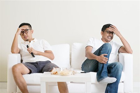 Men sitting on couch watching football match on television together at home. Stock Photo - Budget Royalty-Free & Subscription, Code: 400-08494564