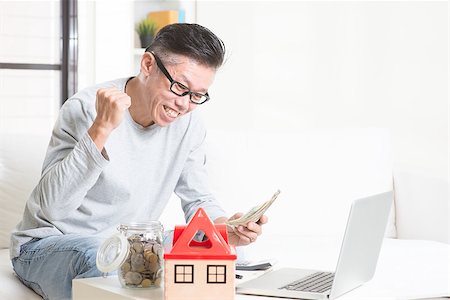 Portrait of happy 50s mature Asian man counting on money and smiling. Saving, retirement, retirees financial planning concept. Family living lifestyle at home. Stock Photo - Budget Royalty-Free & Subscription, Code: 400-08494619