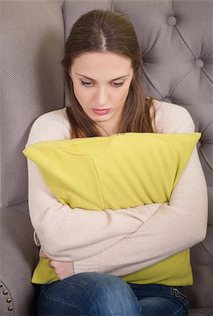 doctor speaking to young patient - Woman with problem on reception for psychologist. Beautiful brunette holding pillow infront on her. Stock Photo - Budget Royalty-Free & Subscription, Code: 400-08494754