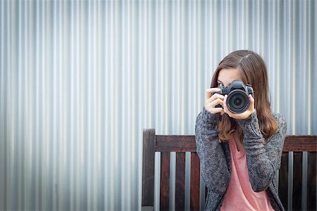 Girl Photographer Sitting On Bench and Pointing Camera. Stock Photo - Budget Royalty-Free & Subscription, Code: 400-08494936