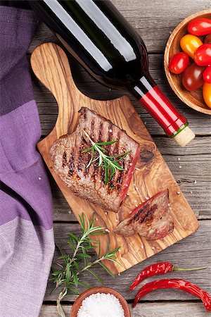 simsearch:400-08495308,k - Grilled beef steak with rosemary, salt and pepper and wine bottle on wooden table. Top view Stockbilder - Microstock & Abonnement, Bildnummer: 400-08495313