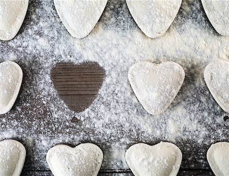 Heart shaped ravioli sprinkle with flour, on wooden background. Cooking dumplings. Top view. Uncooked ravioli hearts Stock Photo - Budget Royalty-Free & Subscription, Code: 400-08495593