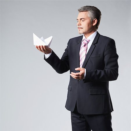 Portrait of businessman holding paper boat. The concept idea Stock Photo - Budget Royalty-Free & Subscription, Code: 400-08495949