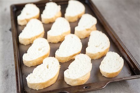 Cut french loaf bread on baking tray. Part of a series of food preparation Stock Photo - Budget Royalty-Free & Subscription, Code: 400-08496644