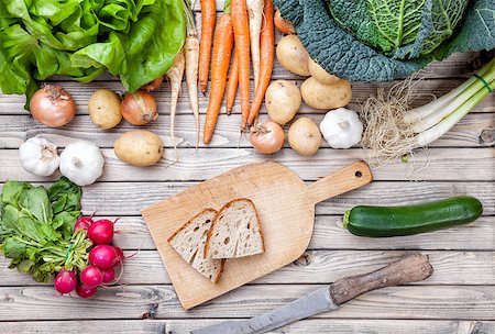 simsearch:400-05384796,k - Freshly cut bread on chopping board with organic vegetables on wooden background Stock Photo - Budget Royalty-Free & Subscription, Code: 400-08498208