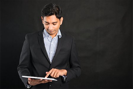 simsearch:400-04485729,k - indian business male using tablet in black background Stock Photo - Budget Royalty-Free & Subscription, Code: 400-08491772