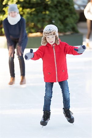 simsearch:400-08034847,k - little boy learning ice skating and his mother watching and cheering up at outdoor skating rink, having winter vacation fun Photographie de stock - Aubaine LD & Abonnement, Code: 400-08492558