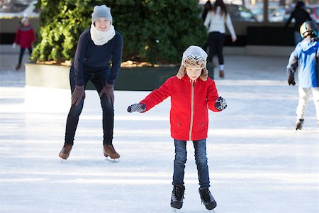 simsearch:400-08318057,k - little boy learning ice skating and his mother watching and cheering up at outdoor skating rink, having winter vacation fun Stock Photo - Budget Royalty-Free & Subscription, Code: 400-08492553