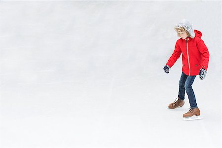 simsearch:400-08318063,k - positive happy boy enjoying winter vacation at outdoor ice skating rink learning ice skating Photographie de stock - Aubaine LD & Abonnement, Code: 400-08493337