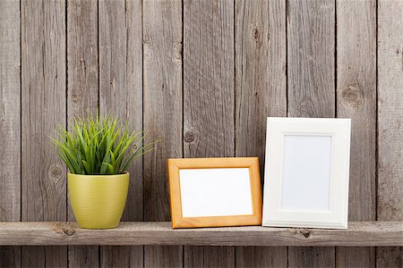 frames on shelf - Blank photo frames and plant on shelf in front of wooden wall Stock Photo - Budget Royalty-Free & Subscription, Code: 400-08493424