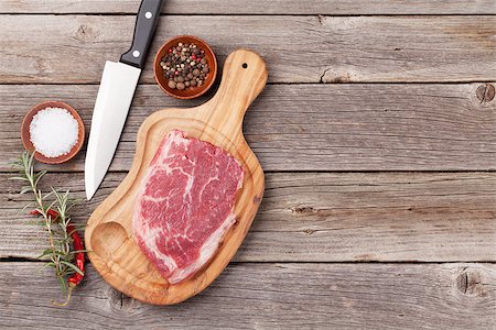 simsearch:400-08495308,k - Raw beef steak and spices on wooden table. Top view vith copy space Stockbilder - Microstock & Abonnement, Bildnummer: 400-08493455