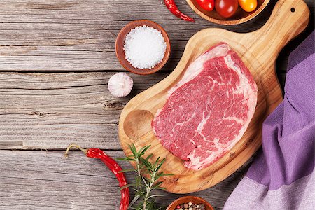 simsearch:695-05773492,k - Raw beef steak and spices on wooden table. Top view with copy space Fotografie stock - Microstock e Abbonamento, Codice: 400-08493458