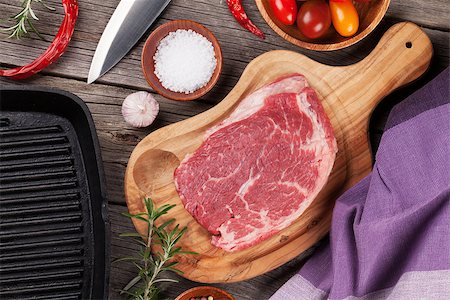 simsearch:400-08495308,k - Raw beef steak and spices on wooden table. Top view Stockbilder - Microstock & Abonnement, Bildnummer: 400-08493459