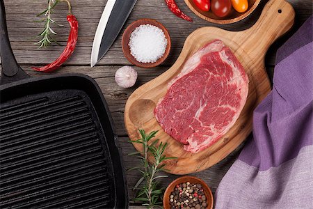 simsearch:400-08495308,k - Raw beef steak and spices on wooden table. Top view Stockbilder - Microstock & Abonnement, Bildnummer: 400-08493460