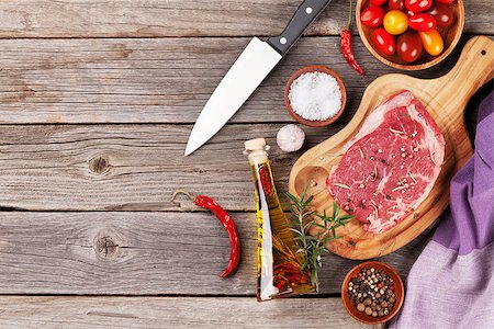 simsearch:400-08495308,k - Raw beef steak and spices on wooden table. Top view vith copy space Stockbilder - Microstock & Abonnement, Bildnummer: 400-08493462