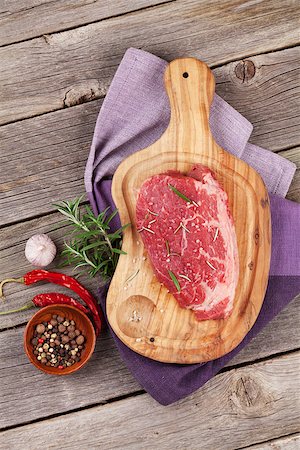 simsearch:400-08495308,k - Raw beef steak and spices on wooden table. Top view Stockbilder - Microstock & Abonnement, Bildnummer: 400-08493463
