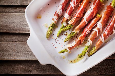 Fresh green asparagus wrapped in parma ham in pan, top view Stock Photo - Budget Royalty-Free & Subscription, Code: 400-08504020