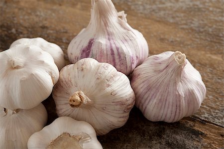 stockarch (artist) - Group of fresh garlic bulbs for use as a pungent aromatic seasoning in cookery lying on a wooden table Foto de stock - Royalty-Free Super Valor e Assinatura, Número: 400-08505312